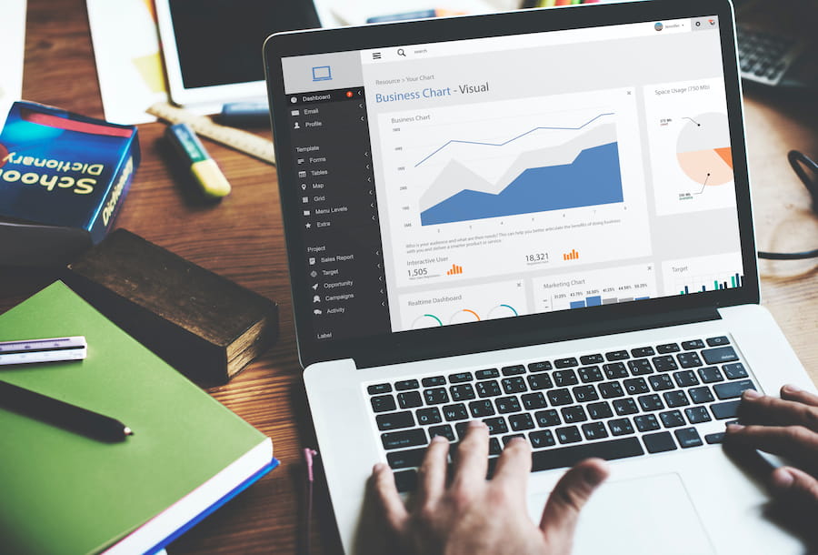 Man Works on Laptop Displaying Business Charts
