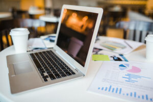 Open laptop, financial document and other objects on workplace of business people