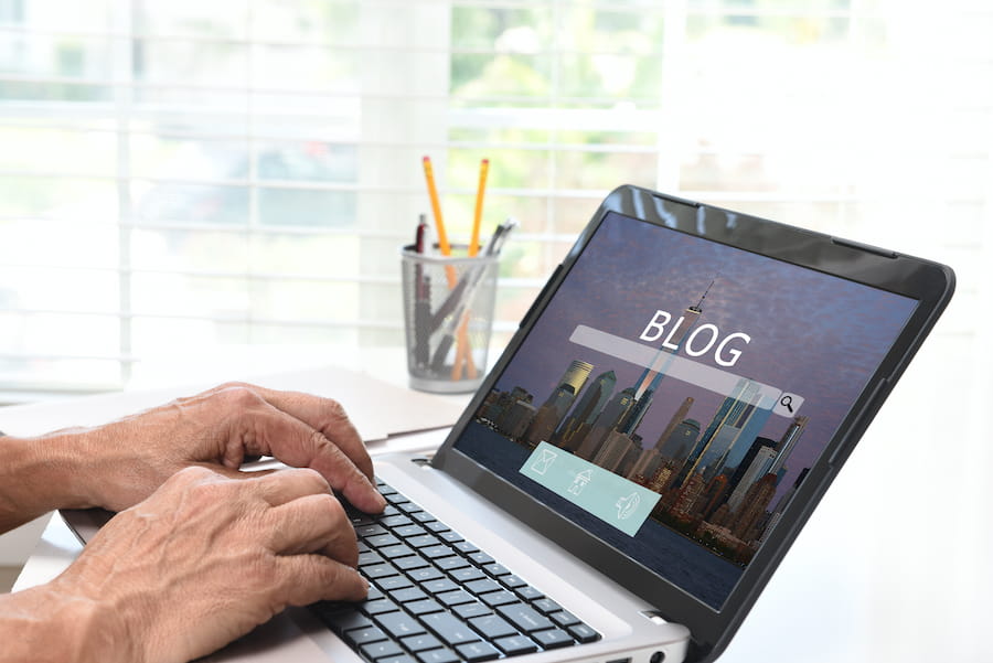 Hands Typing on Laptop with Blog Homepage Displayed