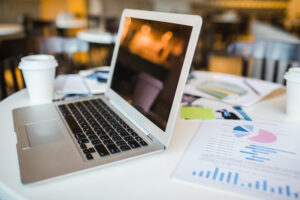Open laptop, financial document and other objects on workplace of business people