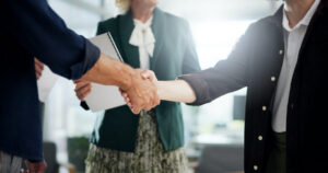 Handshake, deal and business people in office for investment agreement, partnership or meeting. Dis.
