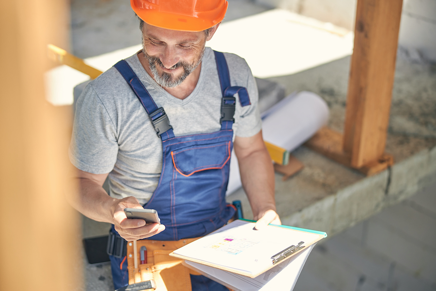 Construction Worker Checks Phone on Building Project